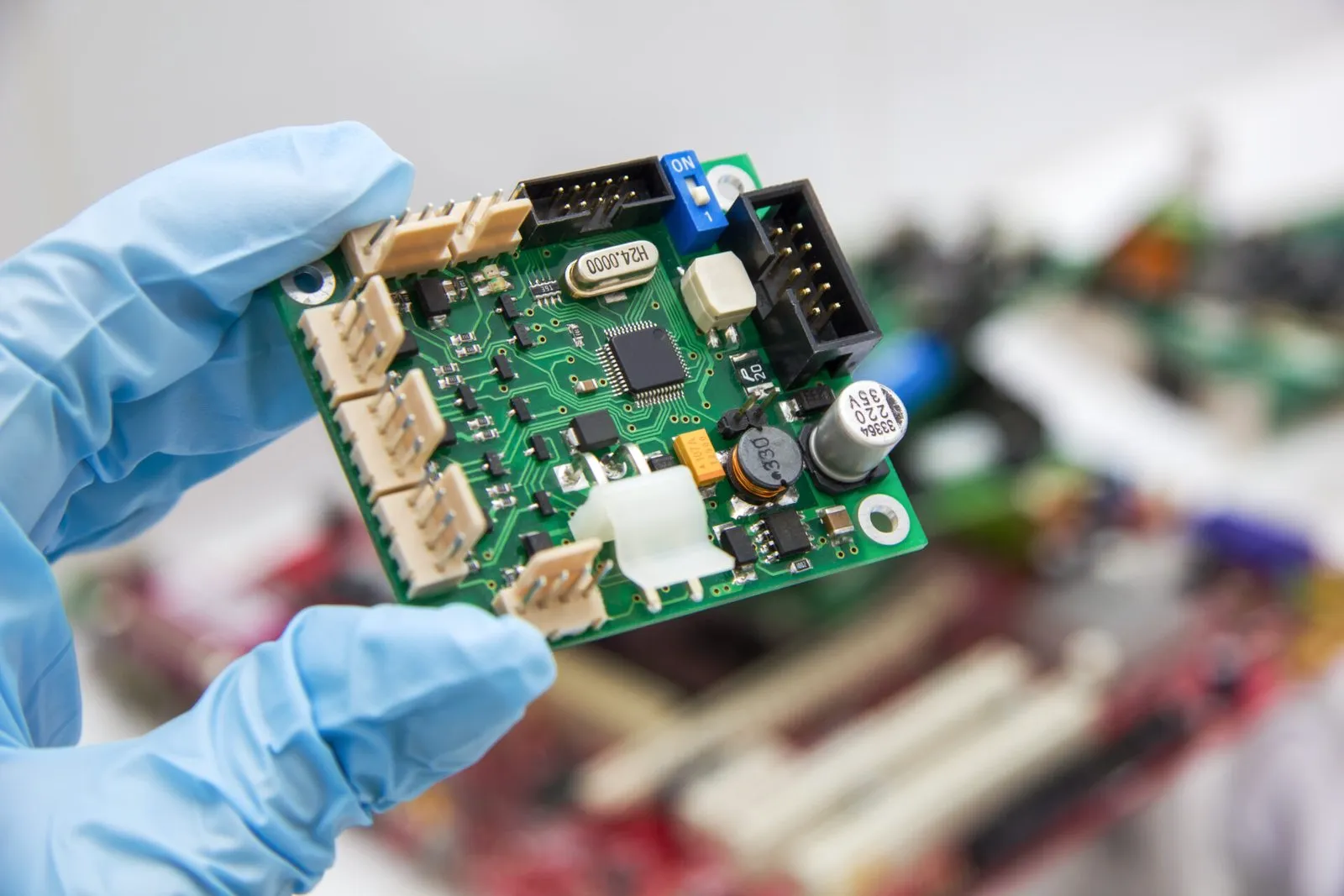 Technician in gloves holding an assembled circuit board